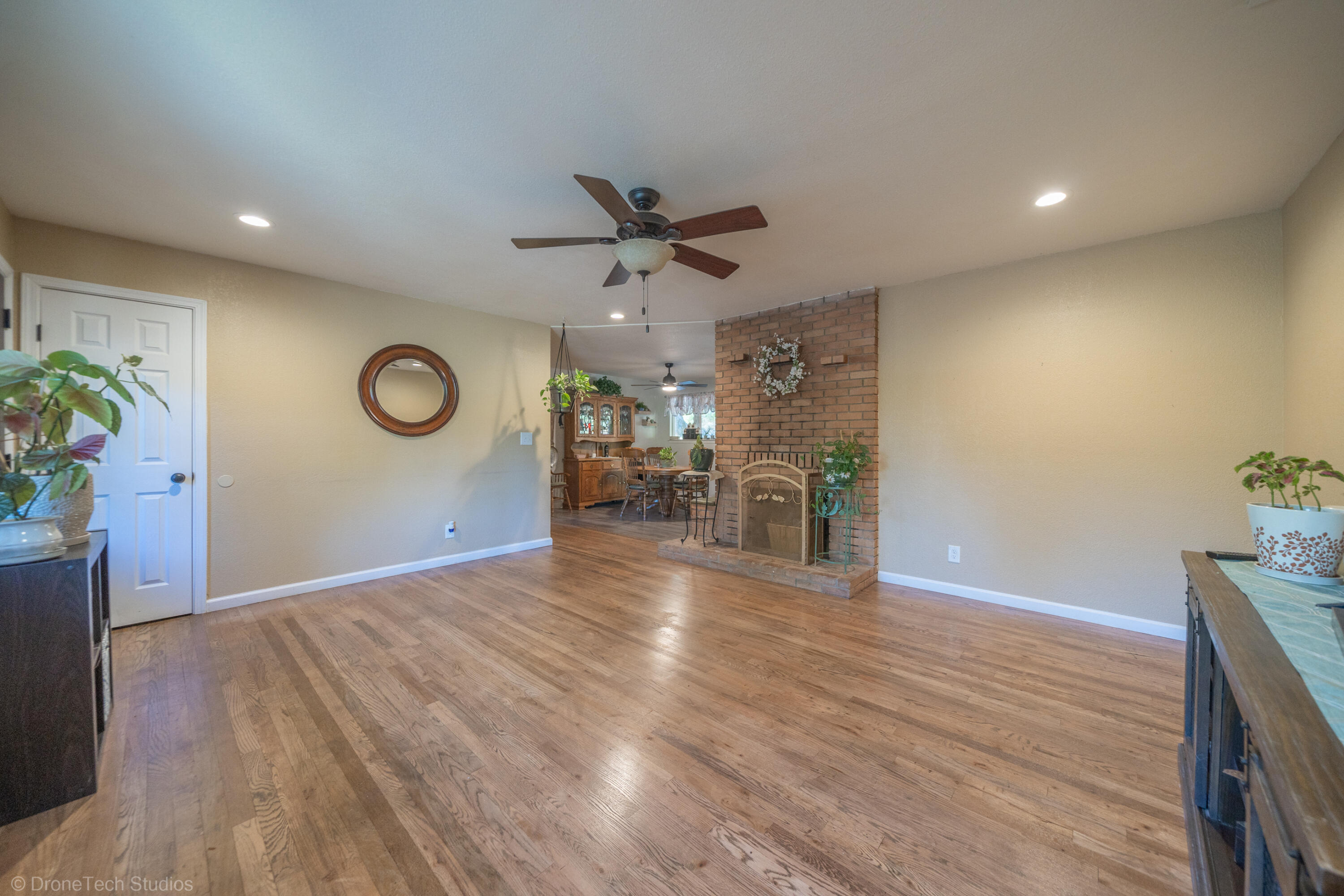 3059 Quartz Hill Road Redding, CA 96003 - Photo 13 of 64 an empty room with wooden floor and a ceiling fan