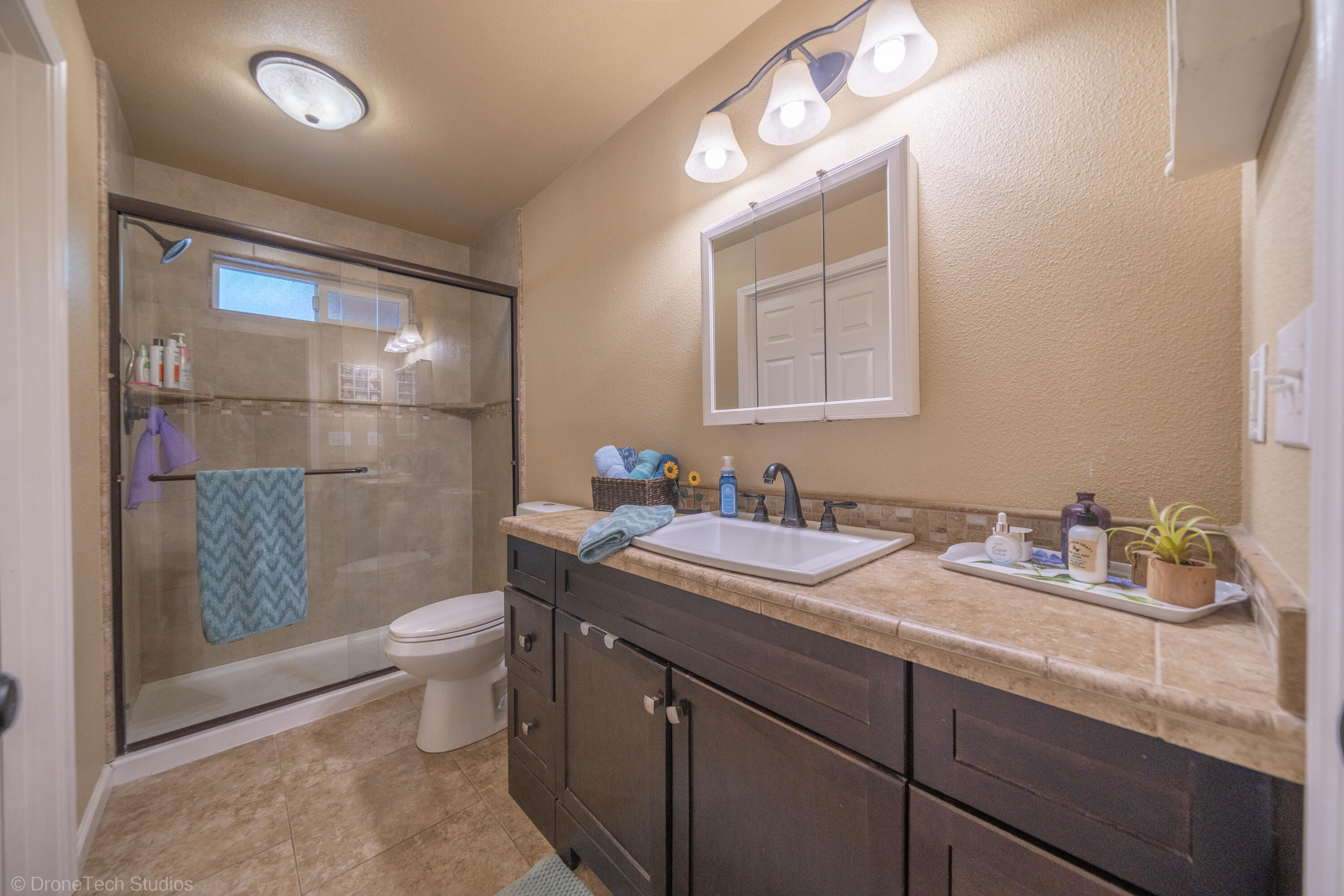 3059 Quartz Hill Road Redding, CA 96003 - Photo 19 of 64 a bathroom with a granite countertop sink mirror vanity and toilet