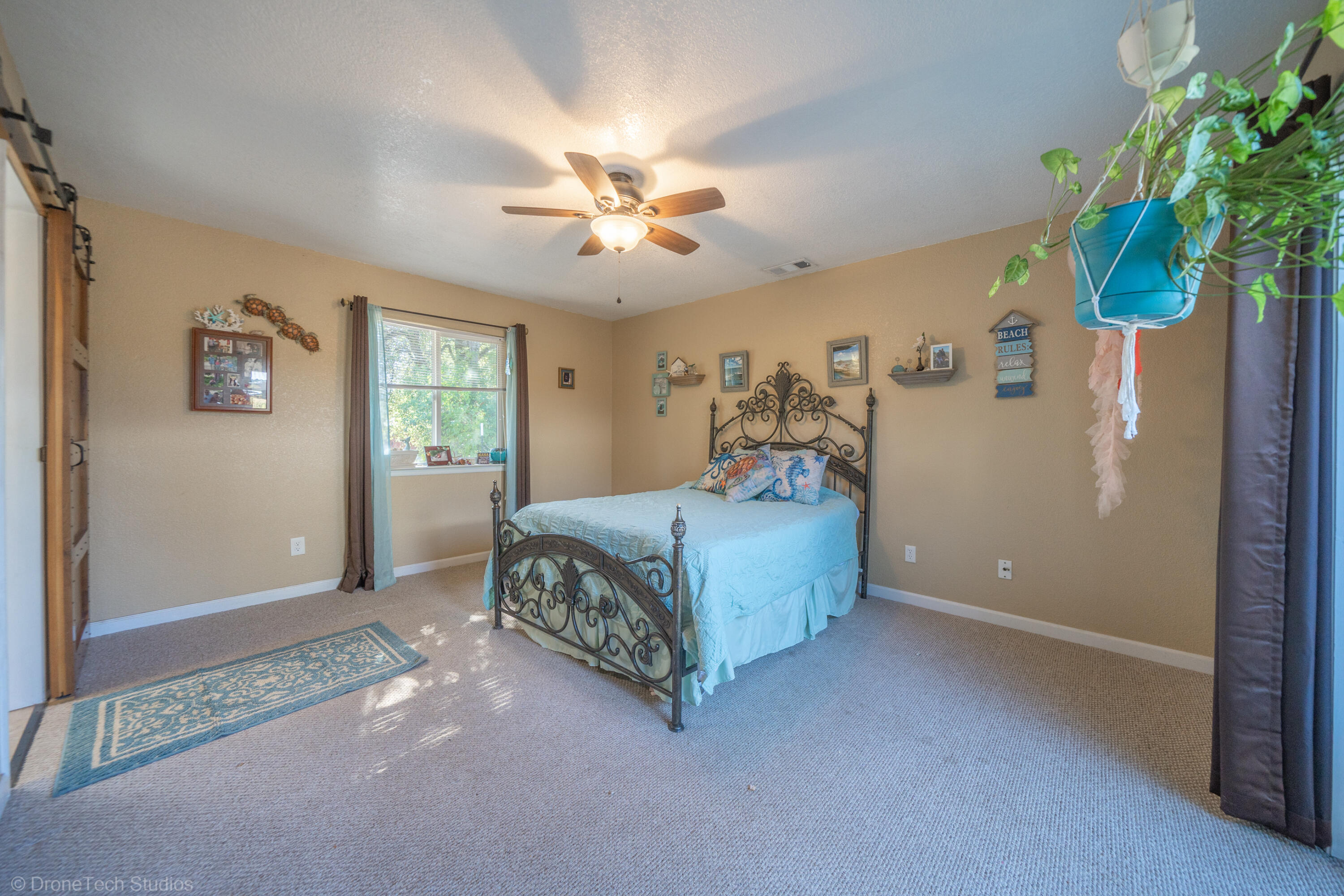 3059 Quartz Hill Road Redding, CA 96003 - Photo 20 of 64 a spacious bedroom with a bed and a chandelier