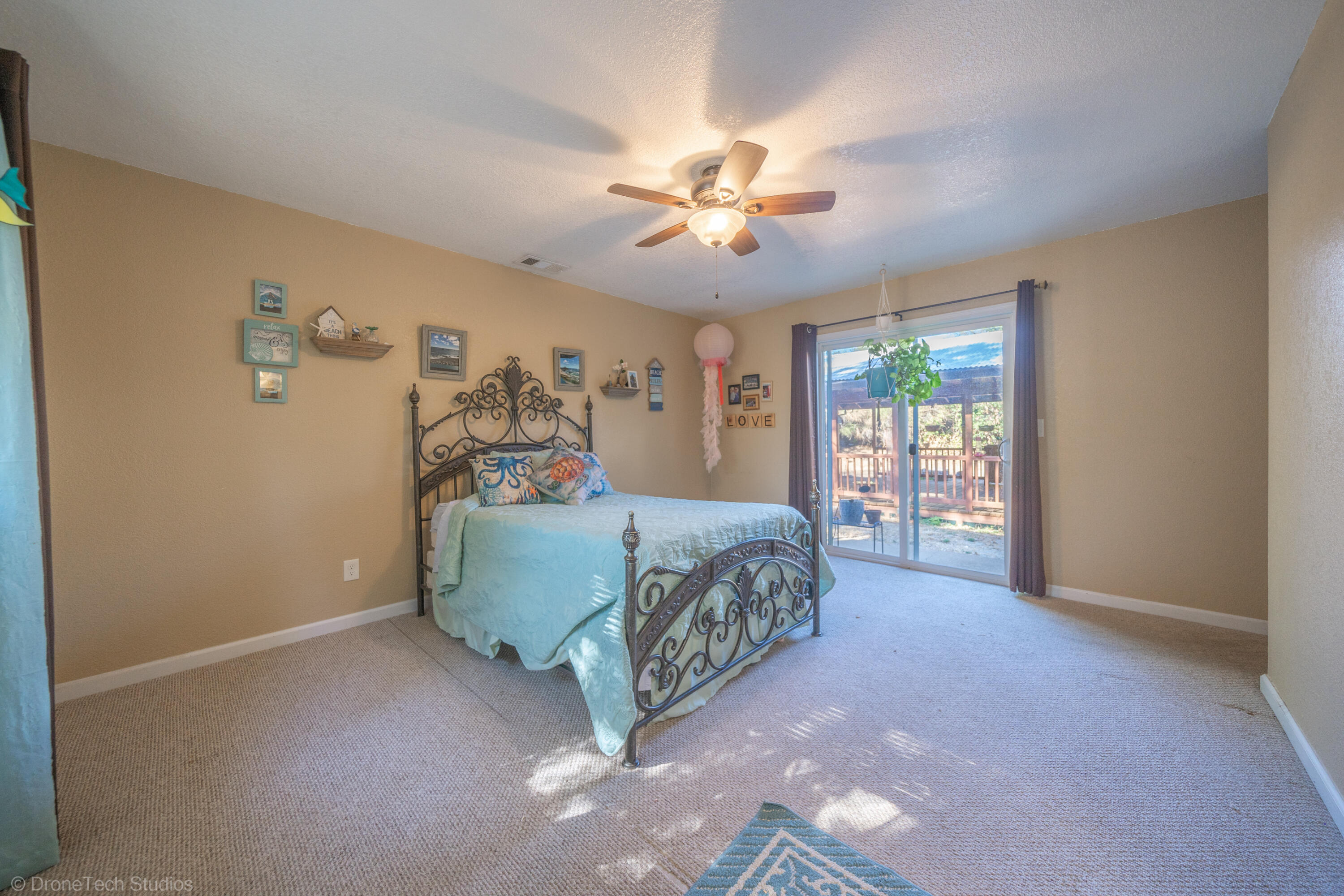 3059 Quartz Hill Road Redding, CA 96003 - Photo 21 of 64 a bedroom with a bed and a chandelier