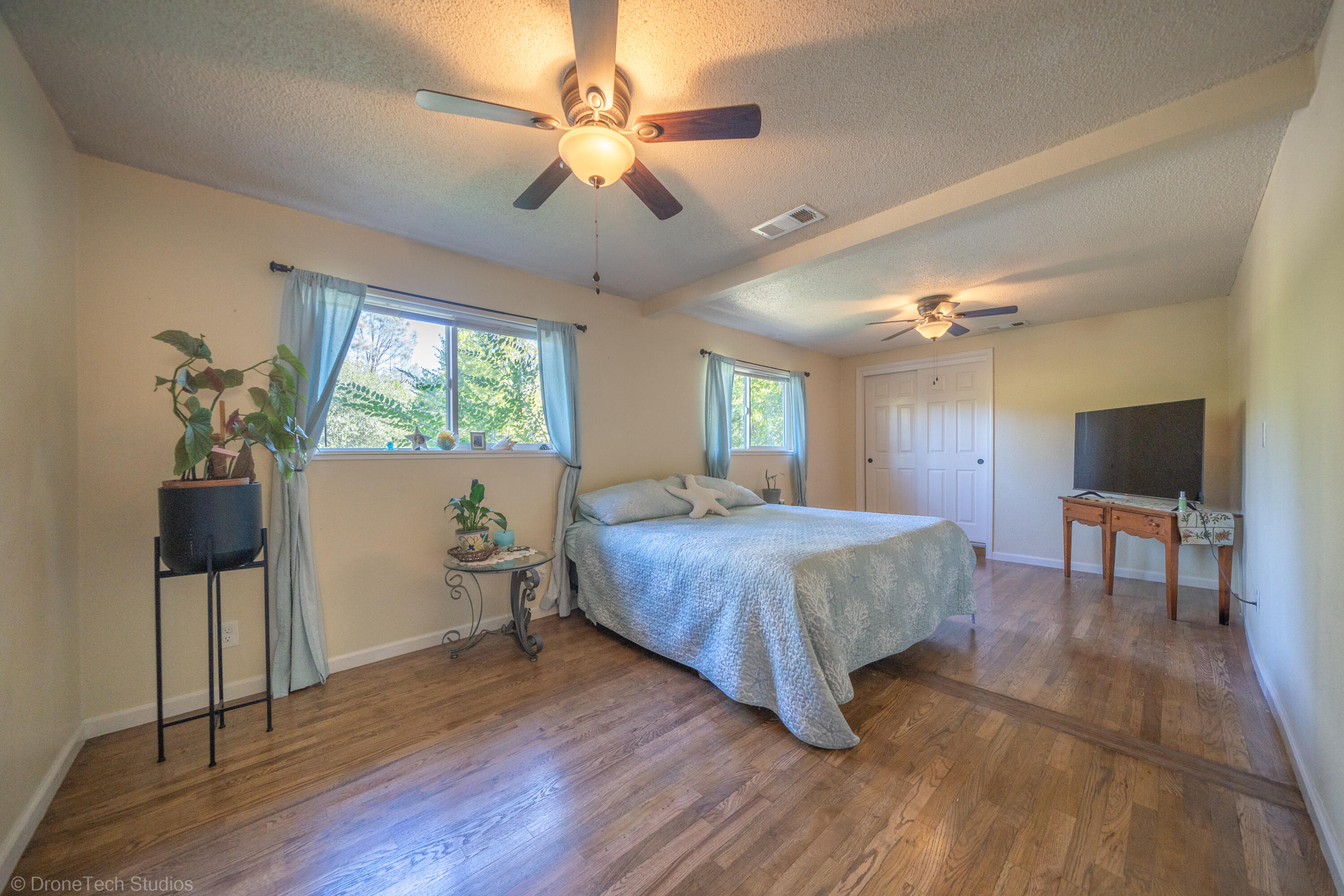 3059 Quartz Hill Road Redding, CA 96003 - Photo 22 of 64 a spacious bedroom with a bed and a chandelier