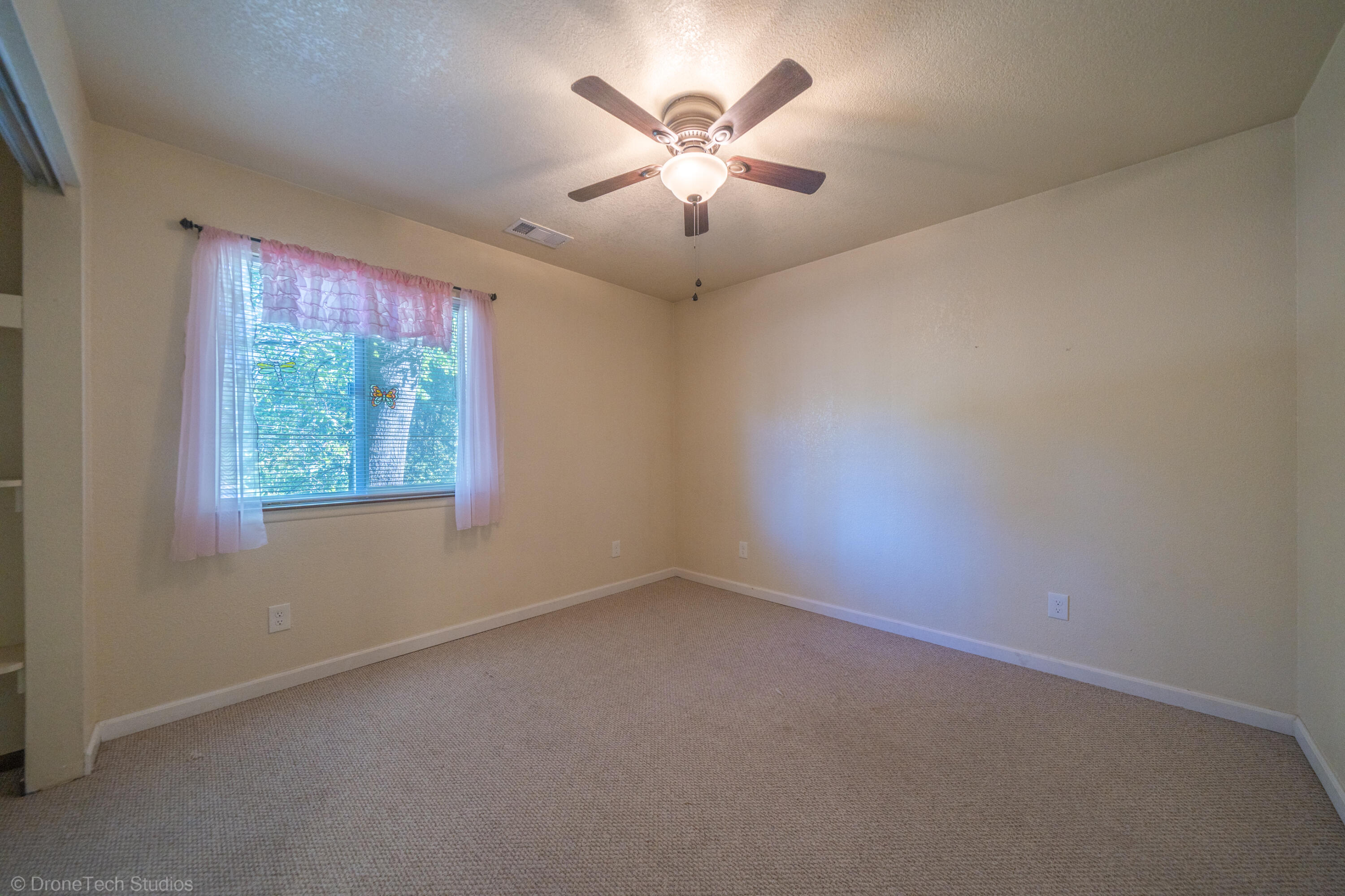 3059 Quartz Hill Road Redding, CA 96003 - Photo 24 of 64 an empty room with windows and fan