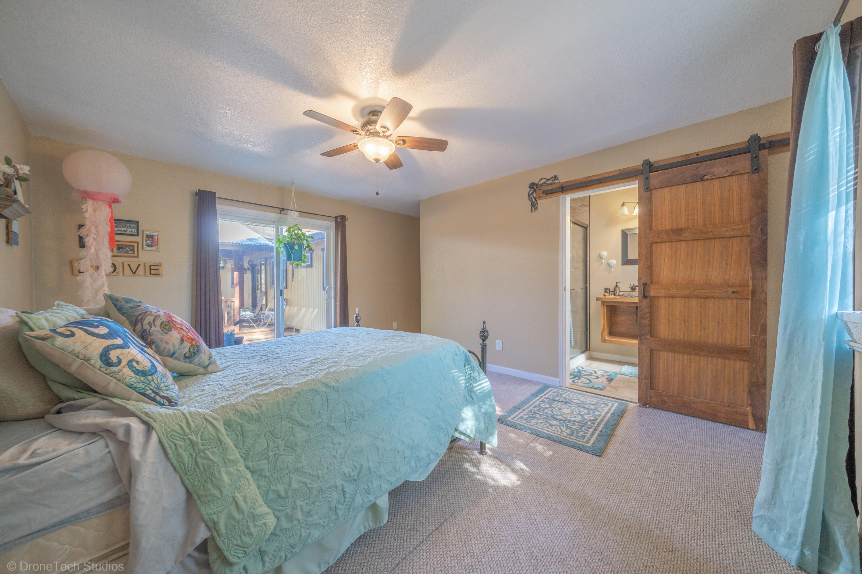 3059 Quartz Hill Road Redding, CA 96003 - Photo 5 of 64 a bedroom with a large bed and a chandelier