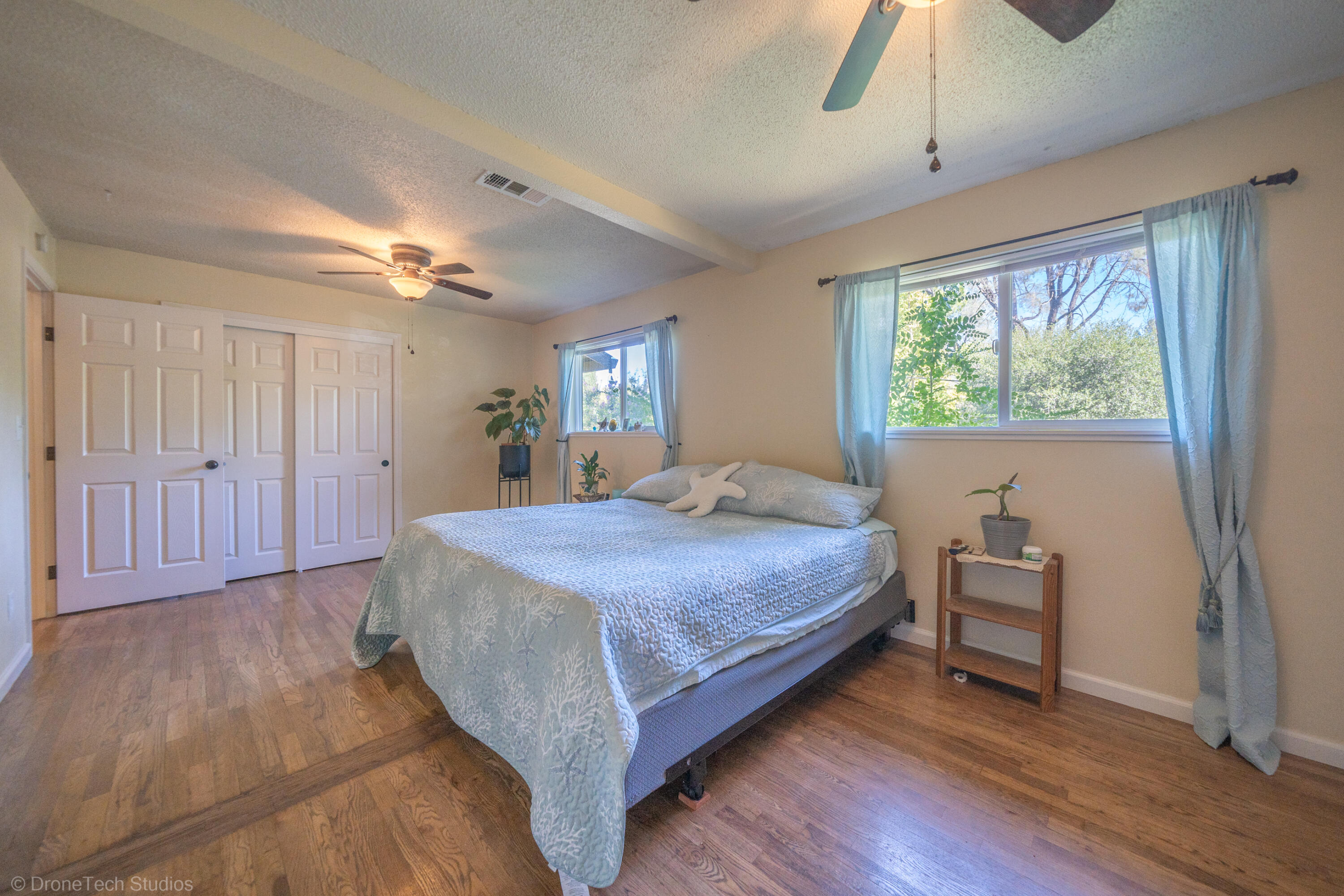 3059 Quartz Hill Road Redding, CA 96003 - Photo 61 of 64 a bedroom with a large bed chandelier and a window