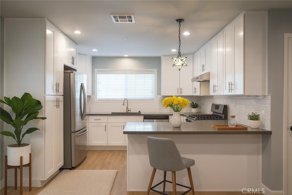 2108 La Paloma Avenue Alhambra, CA 91803 - Photo 3 of 15 a kitchen with stainless steel appliances granite countertop a refrigerator a sink dishwasher a oven with white cabinets and wooden floor
