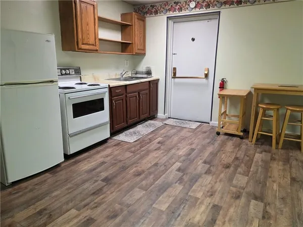 a kitchen with wooden floors and white appliances