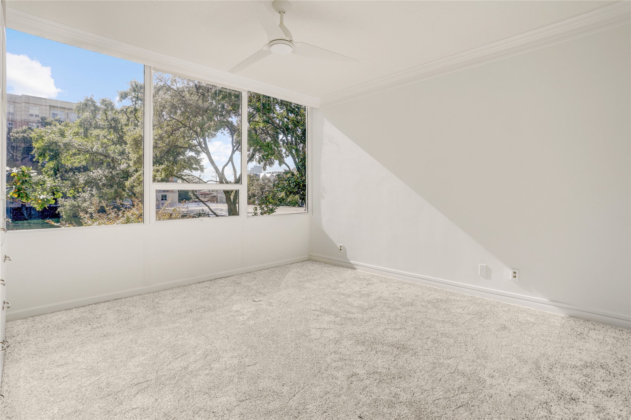 2701 Westheimer Road, Unit 2D Houston, TX 77098 - Photo 13 of 48 A secondary view of the bedroom reveals crisp white walls and newly installed carpeting, reinforcing the space’s calm, light-filled character.