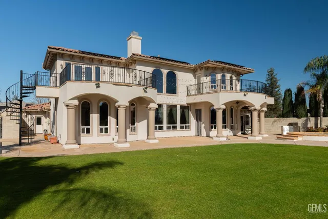 a view of a chair and tables in the patio along a garden