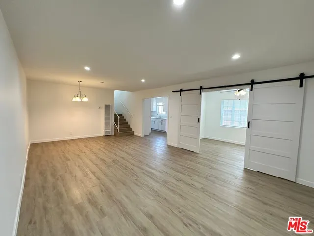 a view of an empty room with wooden floor
