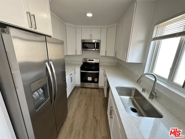 a kitchen with granite countertop a refrigerator and a sink