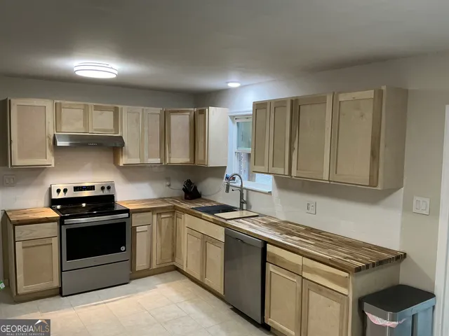 a kitchen with stainless steel appliances a sink stove and cabinets