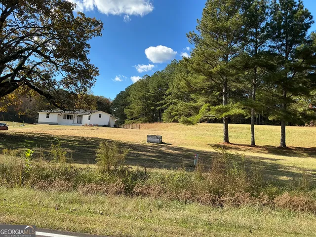 a front view of house with yard and trees in the background