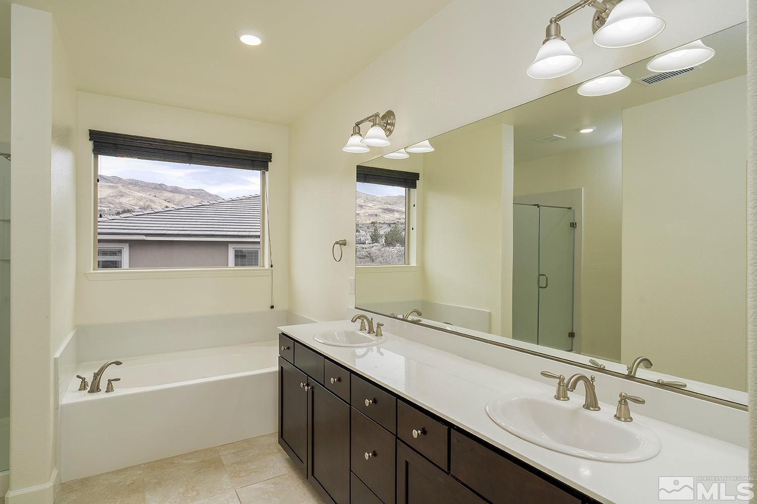 1675 Scott Valley Road Reno, NV 89523 - Photo 33 of 40 a bathroom with a tub a double vanity sink and a mirror