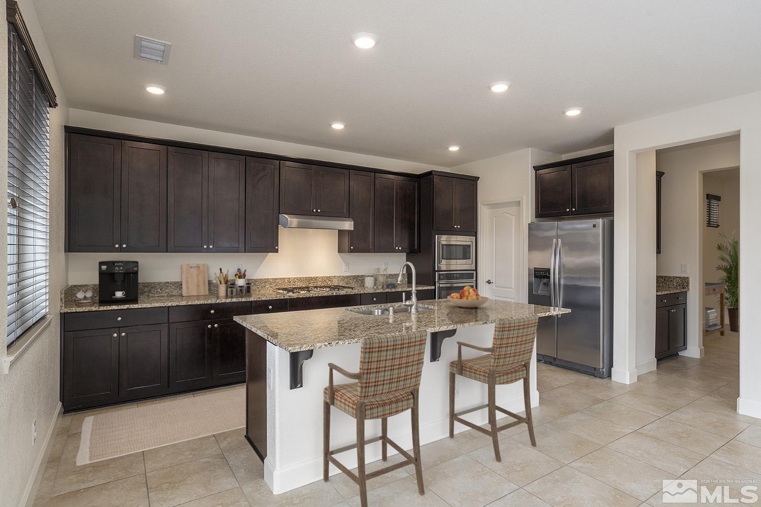 1675 Scott Valley Road Reno, NV 89523 - Photo 10 of 40 a kitchen with stainless steel appliances granite countertop a table and chairs in it