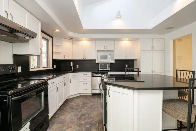 a kitchen with stainless steel appliances granite countertop a stove sink and cabinets