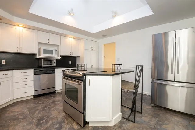 a kitchen with white cabinets and stainless steel appliances