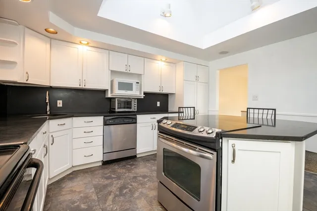 a kitchen with granite countertop a sink stove and cabinets