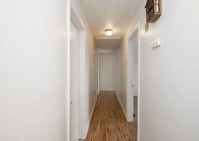 a view of a hallway with wooden floor