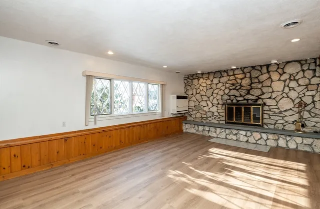 a view of a hallway with wooden floor and a bathroom