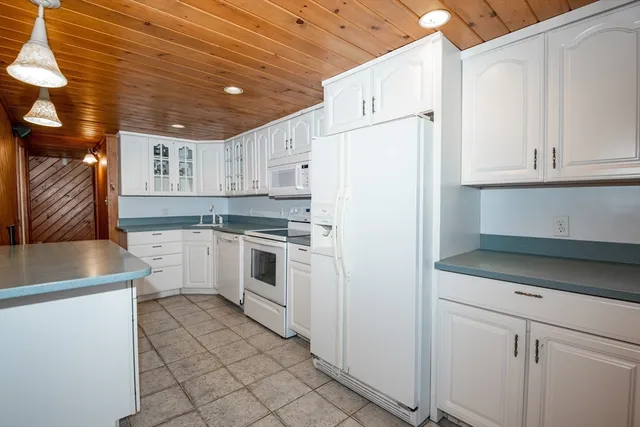 a view of a hallway with wooden floor and a living room