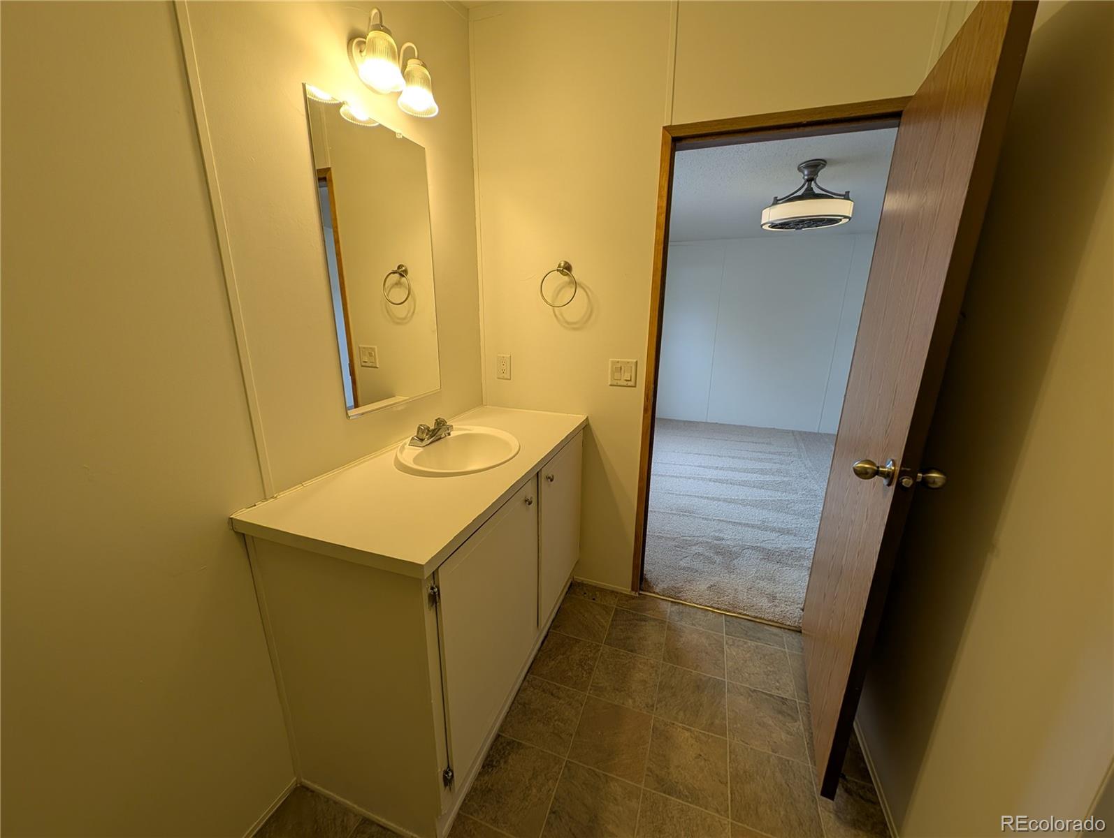 17190 Mt Vernon Road Golden, CO 80401 - Photo 11 of 29 a bathroom with a sink a mirror and a shower