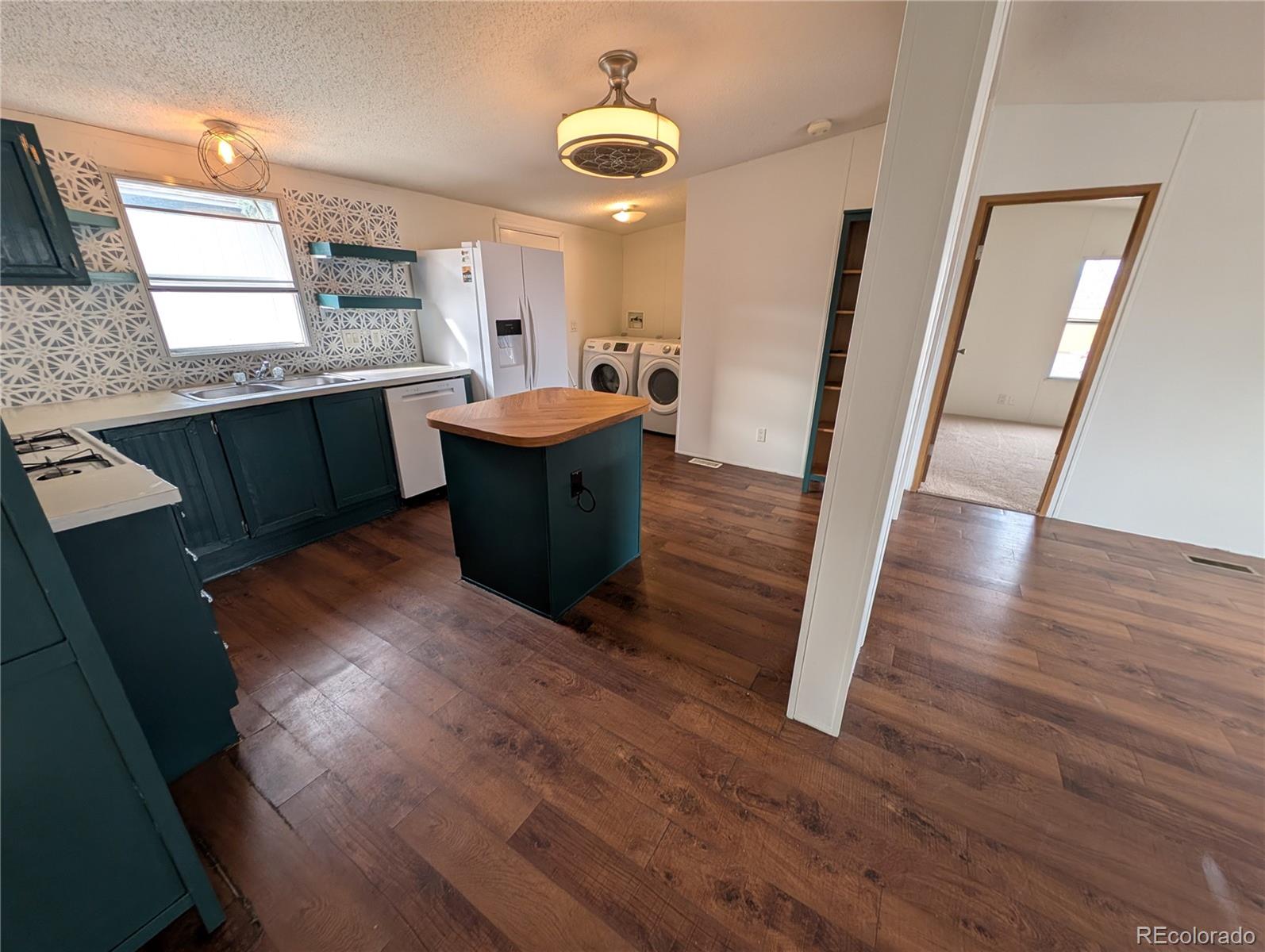 17190 Mt Vernon Road Golden, CO 80401 - Photo 23 of 29 a large kitchen with a sink a window and wooden floor
