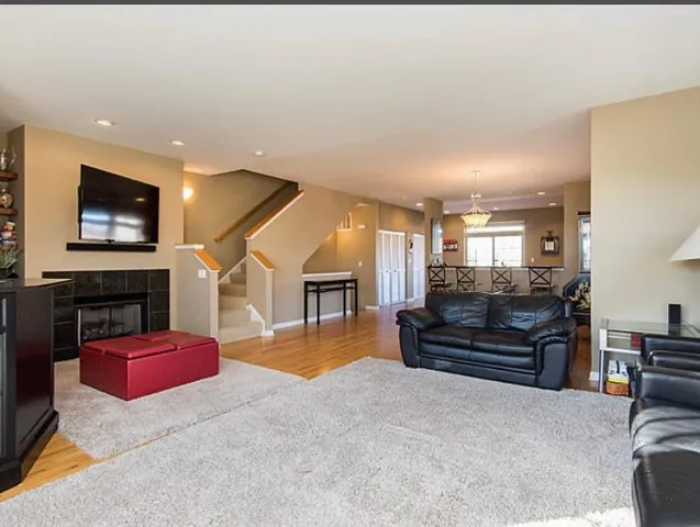 a living room with furniture and a flat screen tv with kitchen view