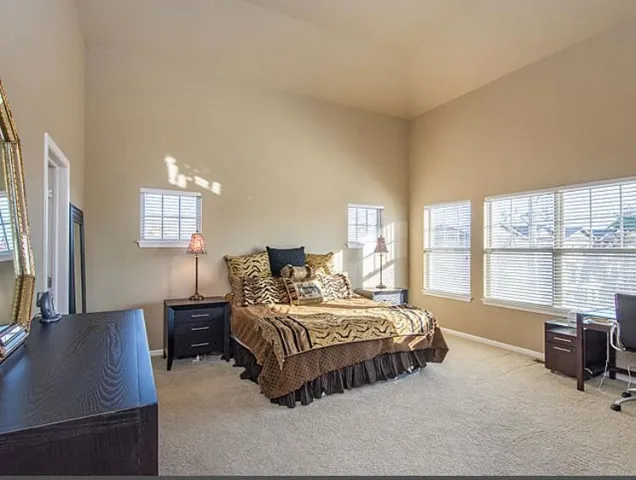 a bedroom with a bed window and a dresser
