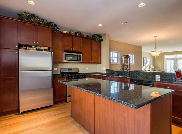 a kitchen with granite countertop a stove sink and refrigerator