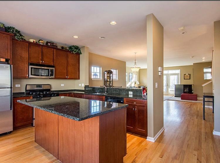 7426 West Fullerton Avenue Elmwood Park, IL 60707 - Photo 10 of 20 a kitchen with kitchen island granite countertop a sink stove and wooden cabinets
