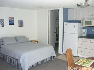 2572 Lemon Road, Unit 1104 Honolulu, HI 96815 - Photo 5 of 7 a bedroom with a bed and a refrigerator