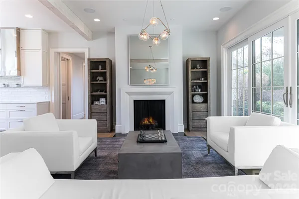 a living room with furniture a fireplace and a chandelier