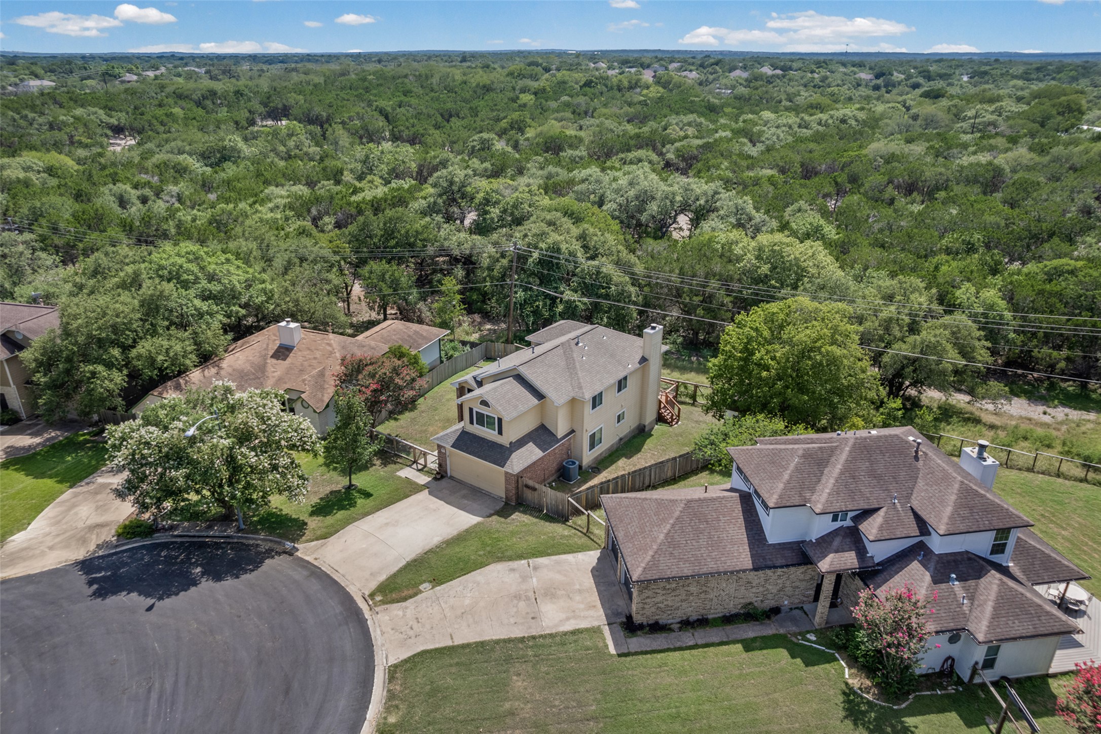 3011 Wadsworth Way Austin, TX 78748 - Photo 1 of 35 An aerial perspective reveals a home nestled within a vibrant, tree-filled landscape on a sunny day.