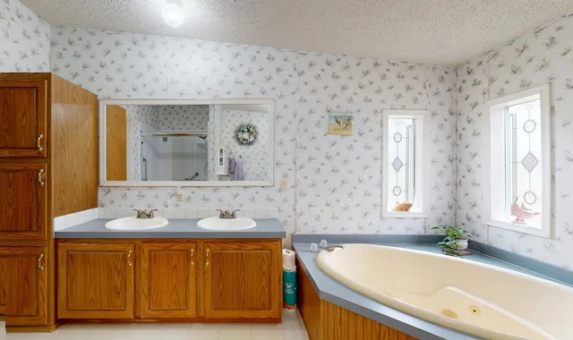 a bathroom with a tub sink and mirror