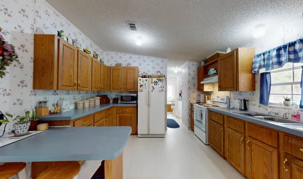 a kitchen with stainless steel appliances a sink dishwasher stove refrigerator and cabinets