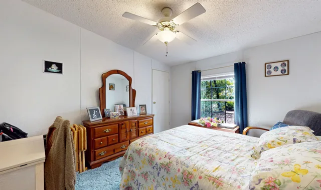 a bedroom with a bed and a dresser with mirror