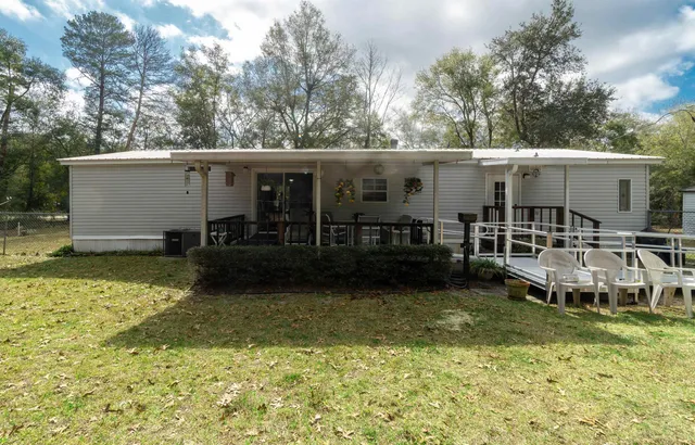 a view of a house with backyard swimming pool and sitting area