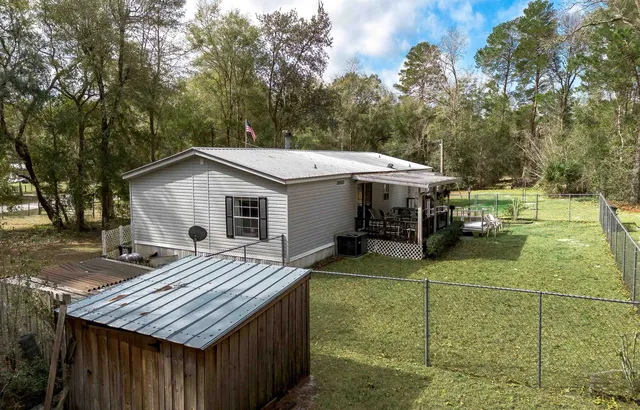 a view of a house with backyard and sitting area