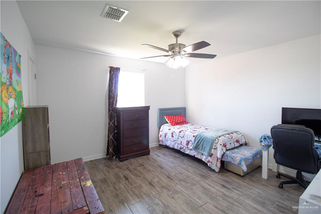 1307 Rio Grande Street San Juan, TX 78589 - Photo 18 of 23 a bedroom with a bed and wooden floor
