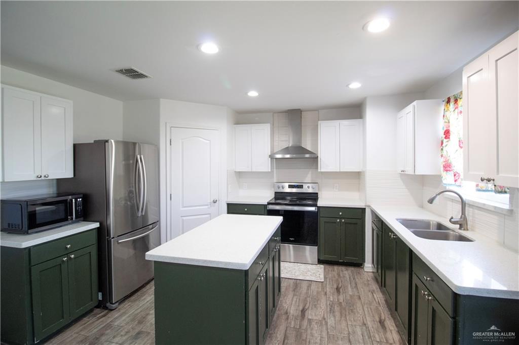 1307 Rio Grande Street San Juan, TX 78589 - Photo 6 of 23 a kitchen with stainless steel appliances a sink stove refrigerator and cabinets