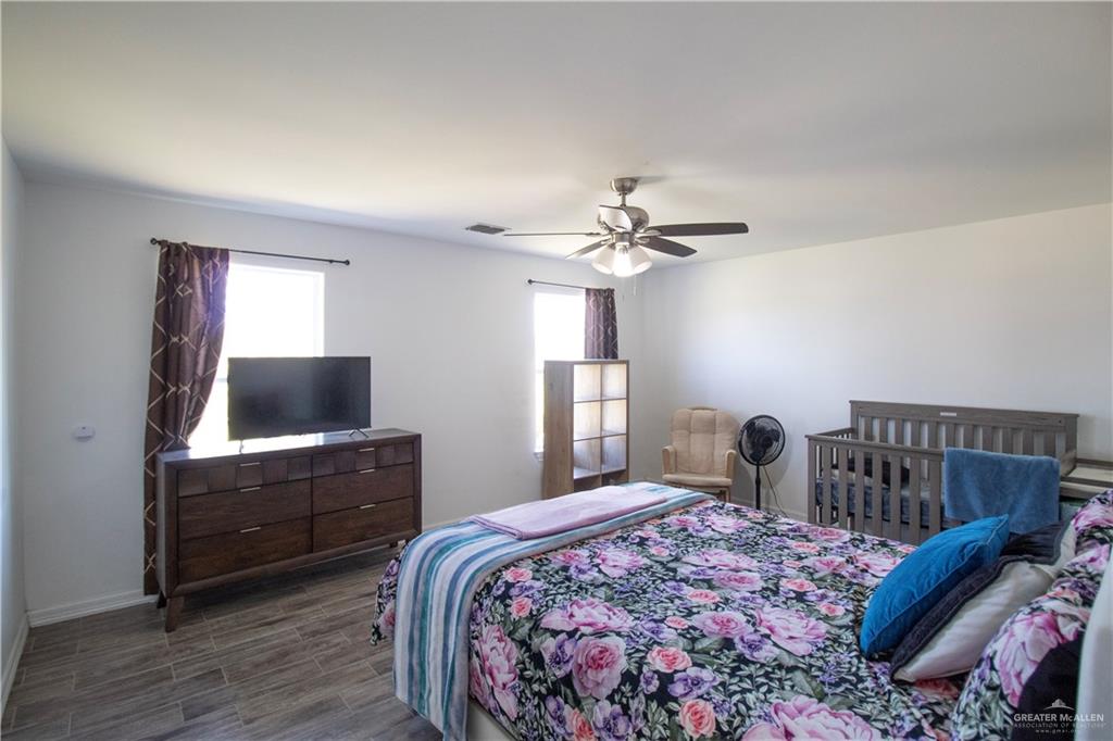 1307 Rio Grande Street San Juan, TX 78589 - Photo 8 of 23 a bedroom with a bed and a flat tv screen on dresser