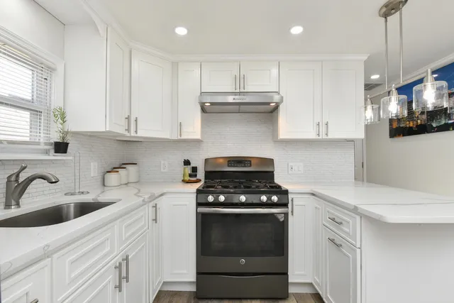 a kitchen with white cabinets and appliances