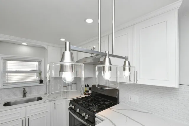 a kitchen with kitchen island a stove a sink and wooden floor