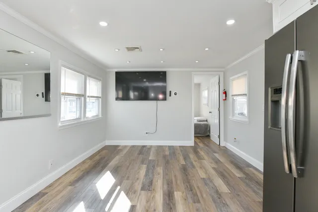 a view of wooden floor in an empty room with a window