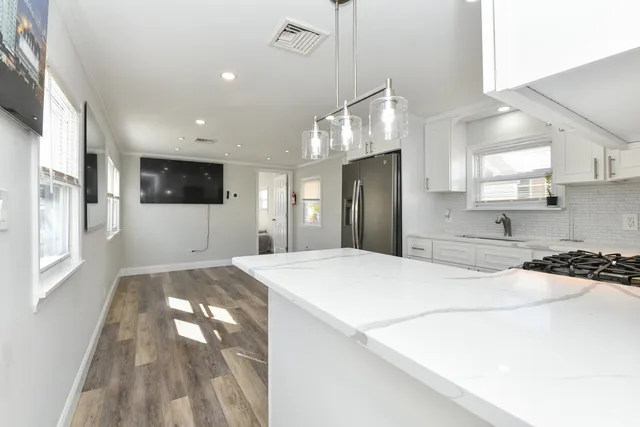 a large kitchen with stainless steel appliances kitchen island a sink stove and refrigerator