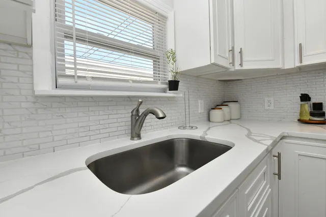 a kitchen with stainless steel appliances granite countertop a sink and a white cabinets