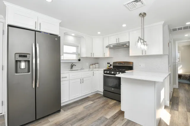 a kitchen with stainless steel appliances a refrigerator sink and stove