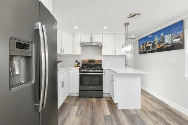 a kitchen with stainless steel appliances a refrigerator sink and stove