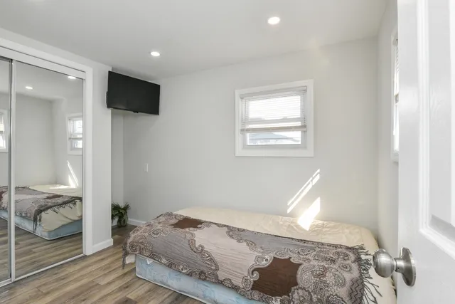 a bedroom with a bed and wooden floor