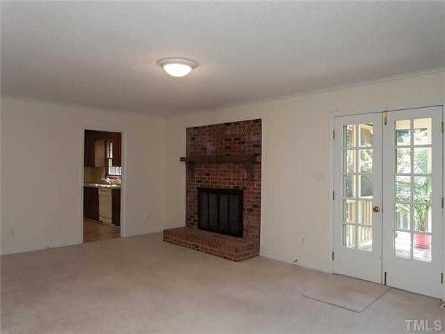 6109 Dodsworth Drive Raleigh, NC 27612 - Photo 11 of 21 Family room with masonry fireplace. French doors lead to screened porch.